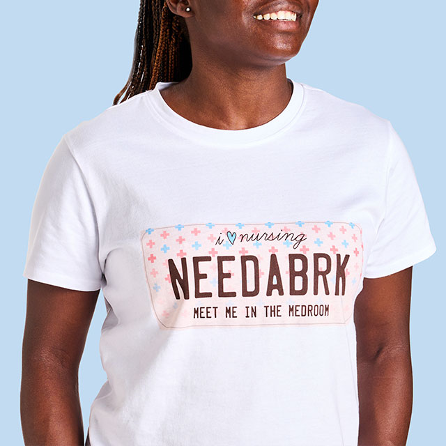 Woman Wearing the White Need a Brk Tee Shirt, on A Light Blue Background