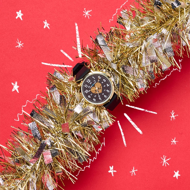 Heart of Gold watch in black shown wrapped around a gold garland. Shop Under $50 Gift Guide. 